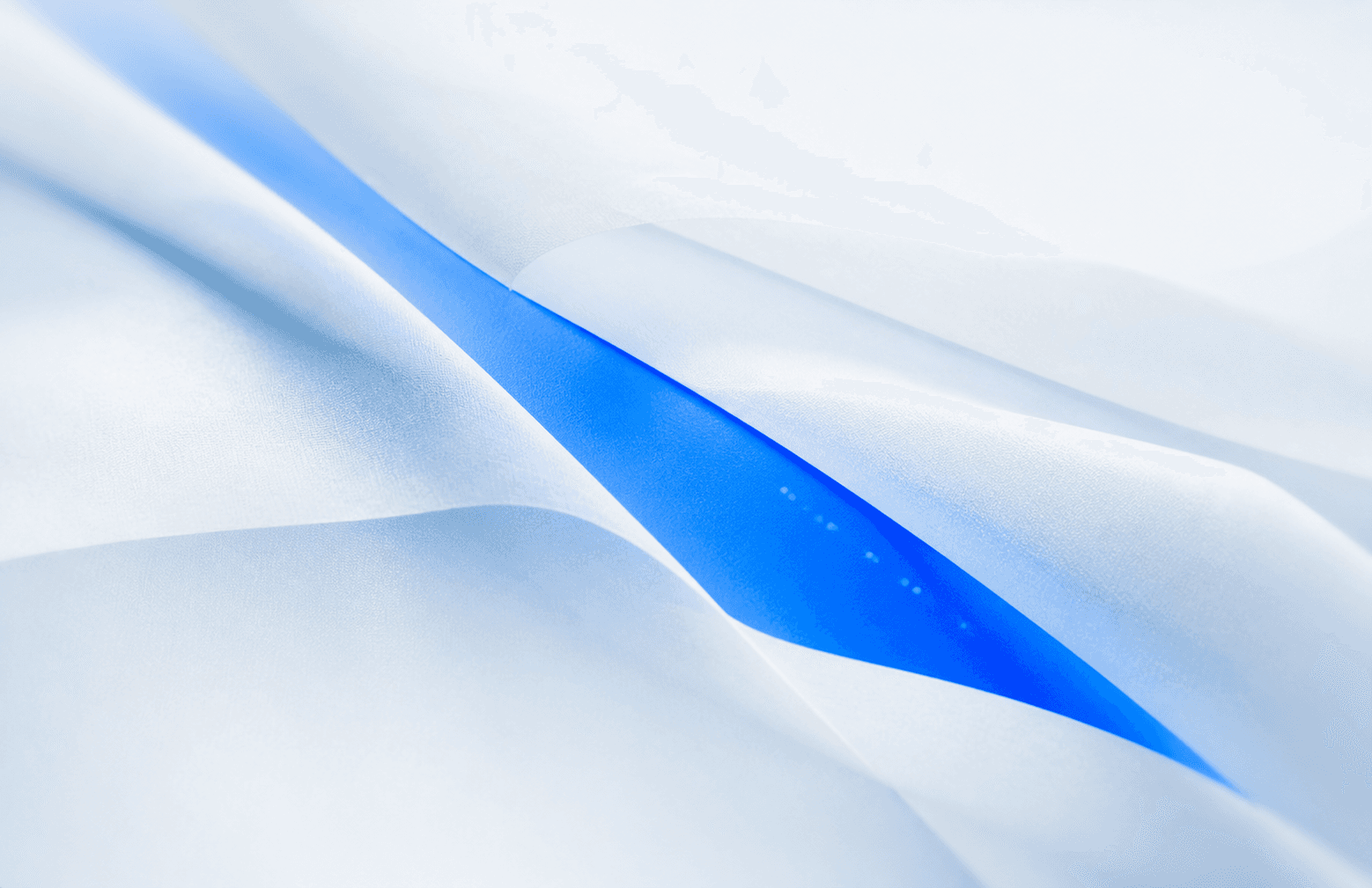 Une couche opérationnelle bleu vif apparaît sous des surfaces blanches délicatement pliées.